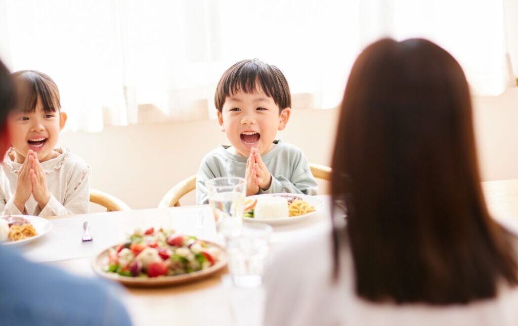 男の子と女の子が両親といただきますをしている様子
