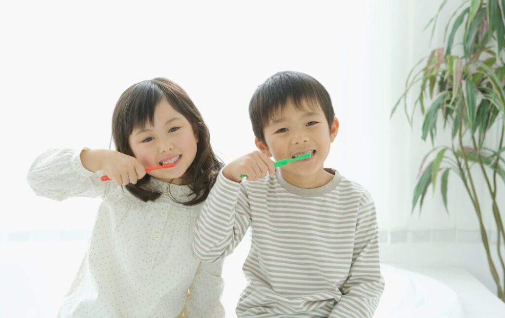 男の子と女の子が並んで仲良く歯磨きをしている